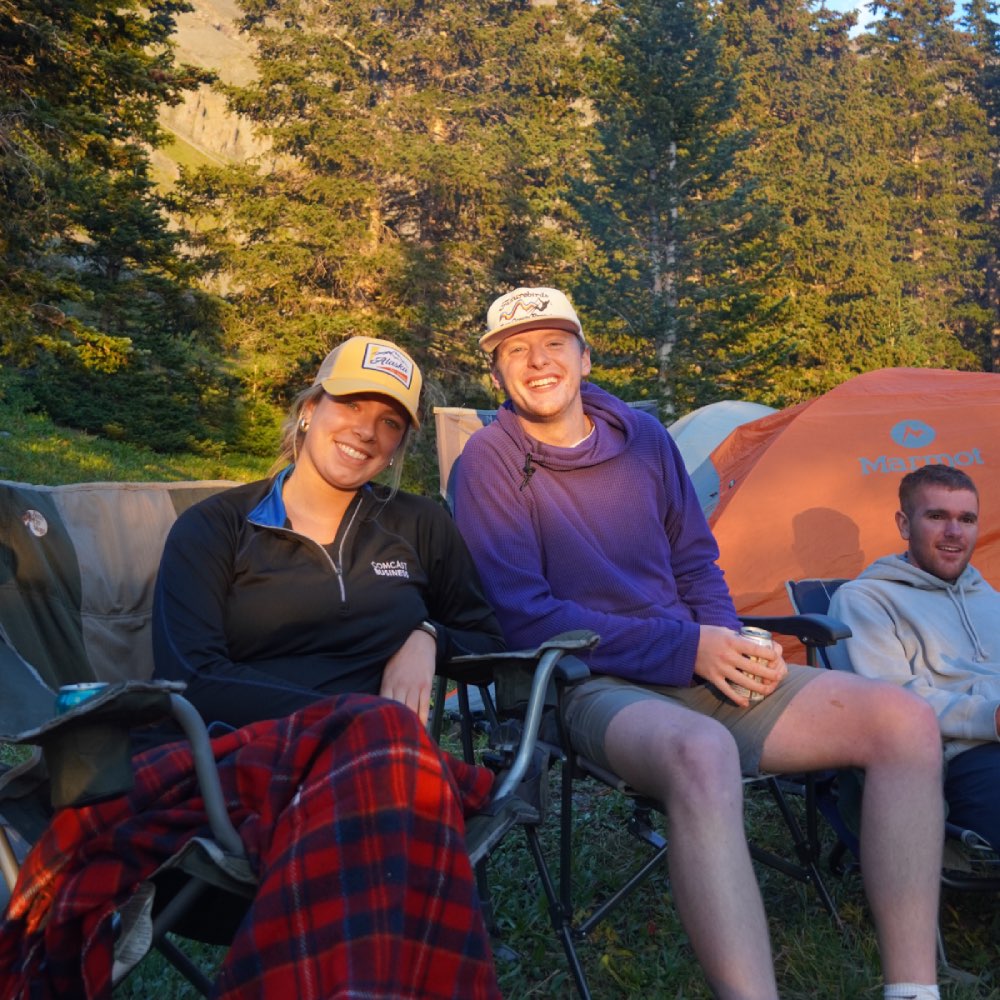 2 people sitting at campsite